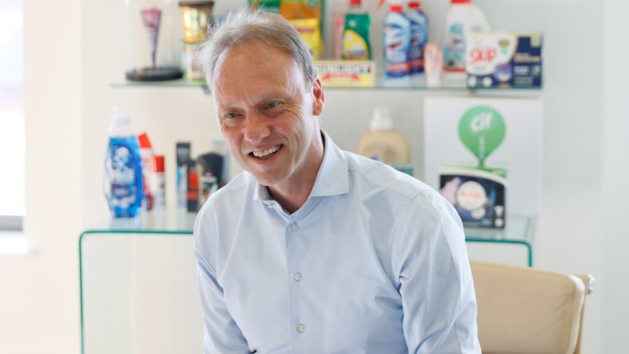 Hein Schumacher is seated and smiling during an interview