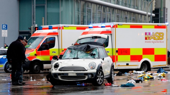 Members of the emergency services work at the scene where a car drove into a crowd in the southern German city of Munich
