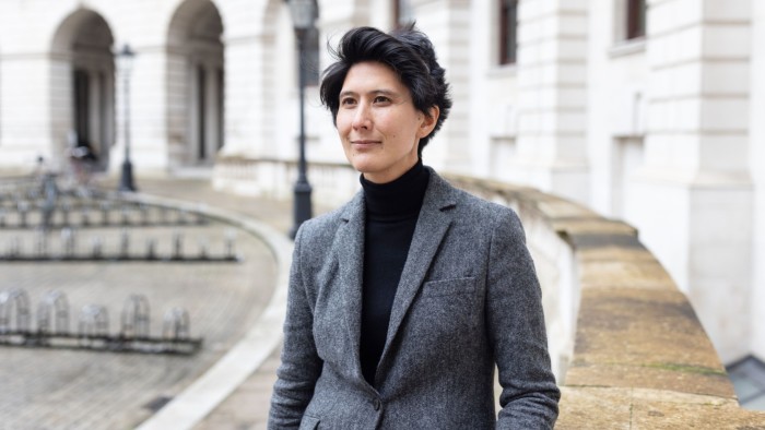 Senior civil servant Cat Little standing in front of a government building
