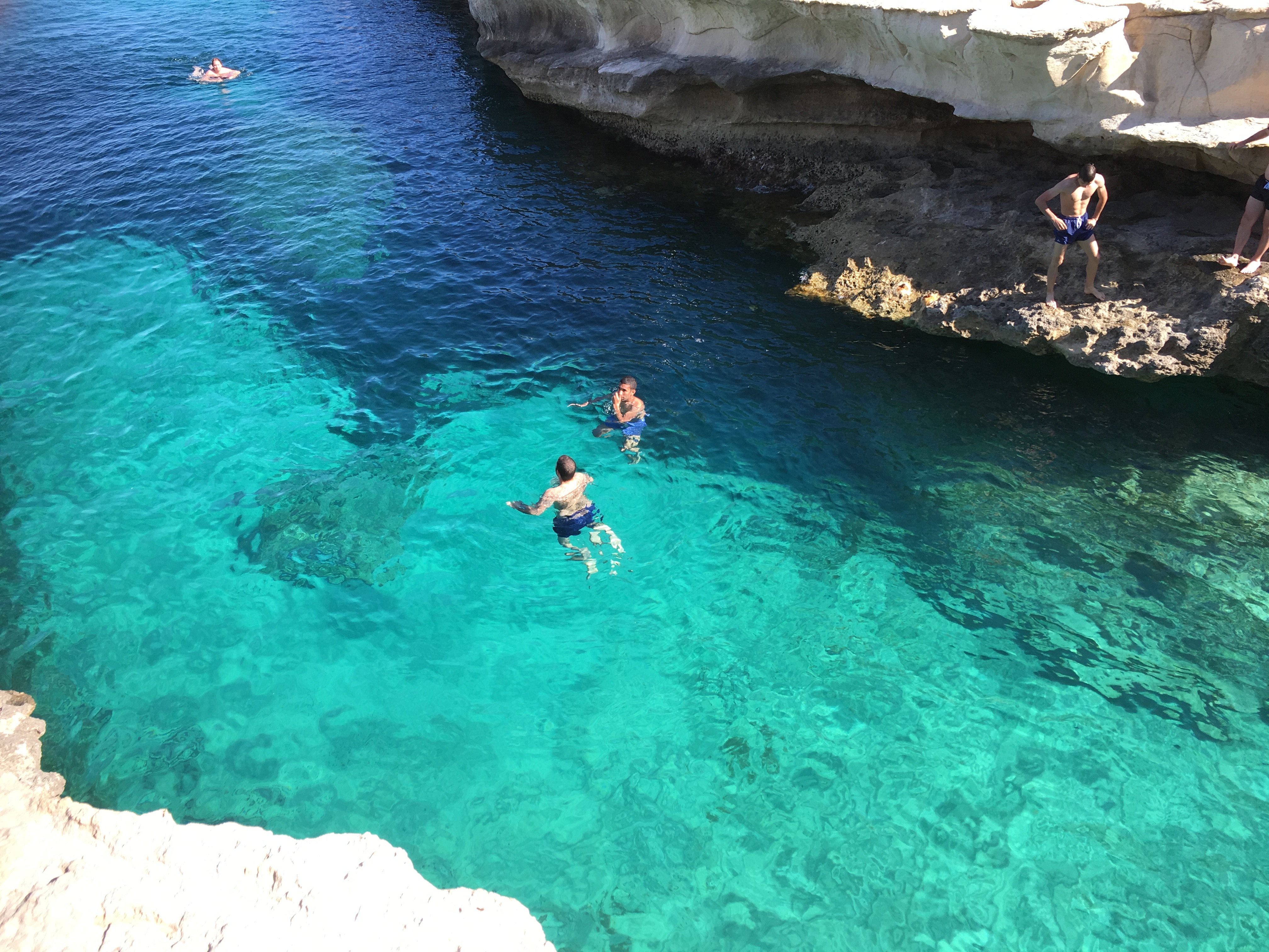 A few people swim in the turquoise waters of Malta. Photo supplied by the author, Drew Limsky.