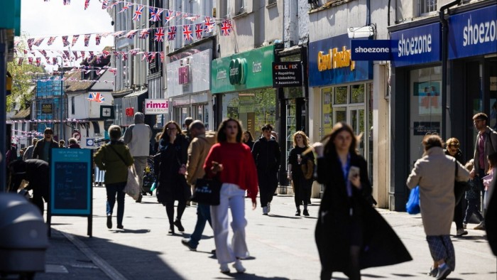 Shoppers pass along the high street in Maidstone, UK