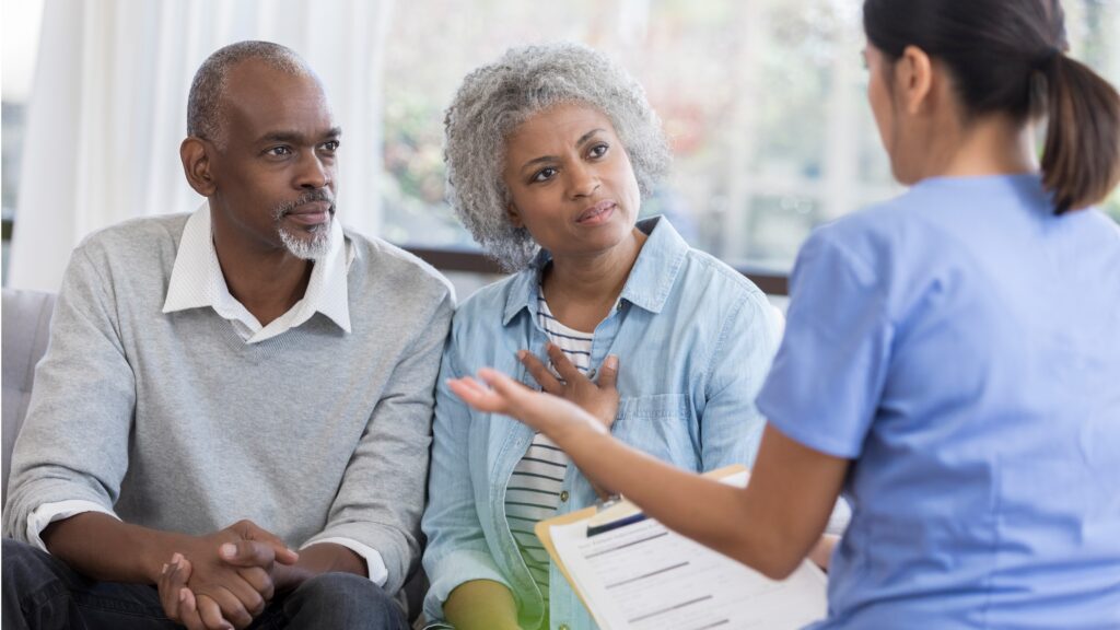 A nurse talks with an older couple.