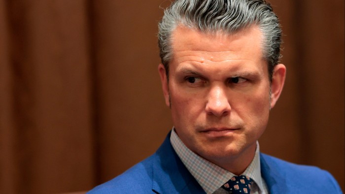 Pete Hegseth  looking to his right with a serious expression.