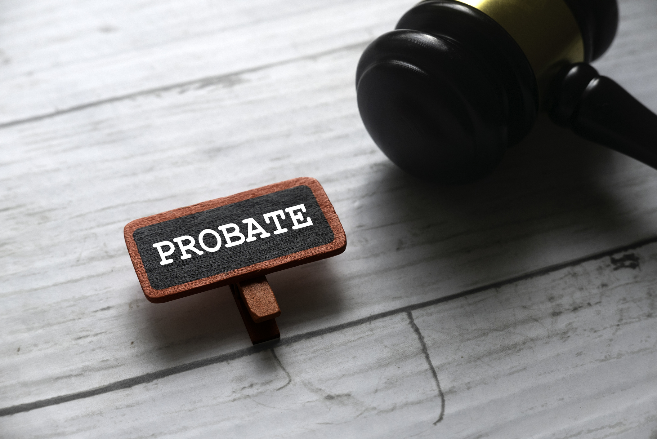 Selective focus of gavel and red tag written with PROBATE on white wooden background.