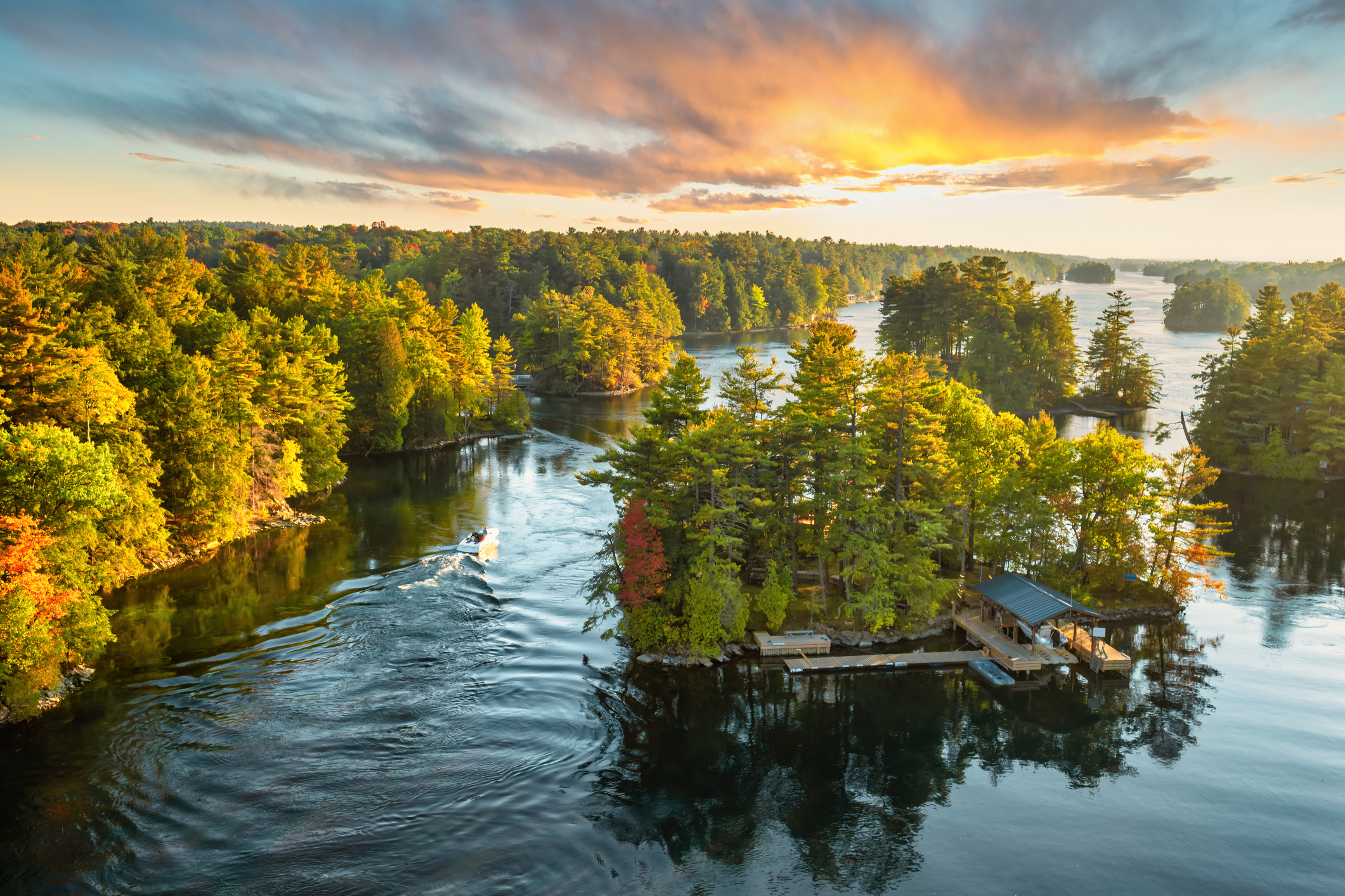 sunset view on the St. Lawrence River with a speedboat in the water