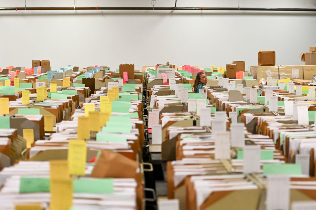 An IRS employee walks through tax documents in the staging warehouse at a Internal Revenue Service facility in Ogden, Utah. (Photo by Alex Goodlett for The Washington Post via Getty Images)