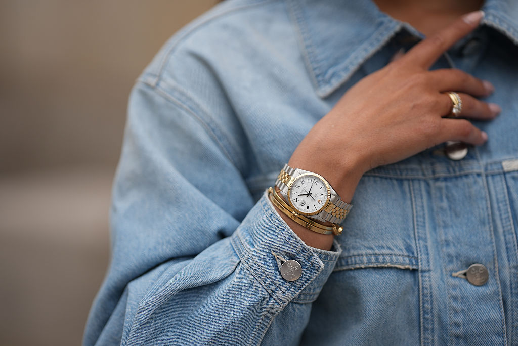 Laura Noltemeyer is seen wearing a light blue worker-style jacket with a classic shirt collar and chest pockets from Closed, a small Lady-Datejust watch in gold-silver from Rolex, a golden LOVE bracelet from Cartier, stacked golden rings from Cartier on May 7, 2025 in Hamburg, Germany.
