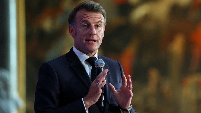 French President Emmanuel Macron gestures as he speaks at the Choose France summit near Paris on Monday
