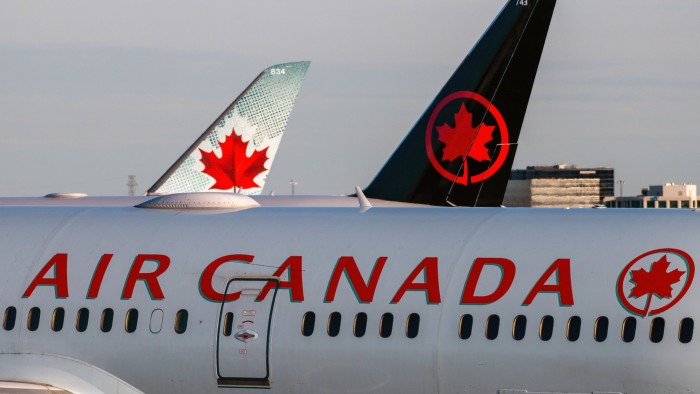 Air Canada planes wait at an airport