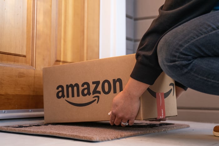 Consumer picking up an Amazon package from their doorstep.