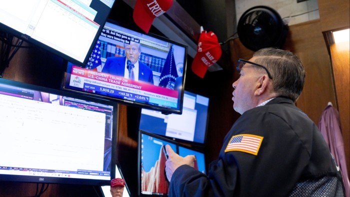 President Donald Trump is seen on a television screen while a trader works on the floor of the New York Stock Exchange on May 12 2025