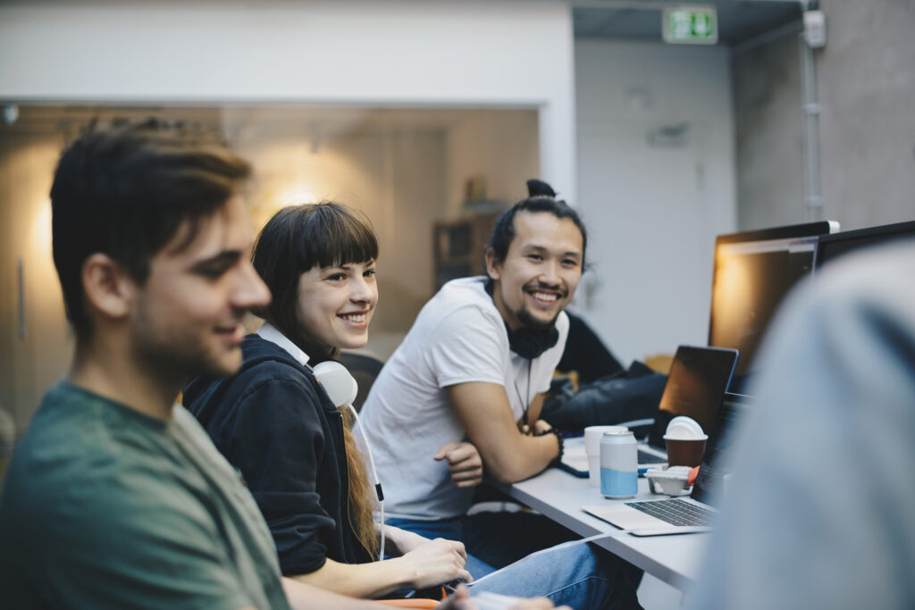 Young, happy computer coders in an office.
