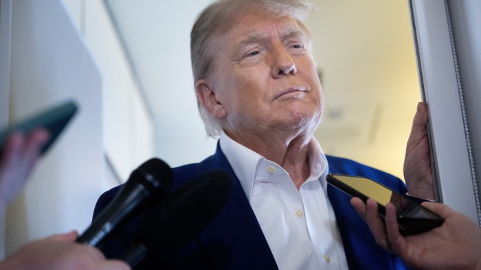 Donald Trump speaks to reporters aboard Air Force One