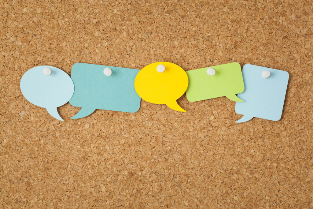 five post it notes on a cork board