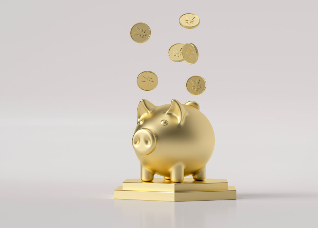 gold piggy bank on top of a book with gold coins floating above