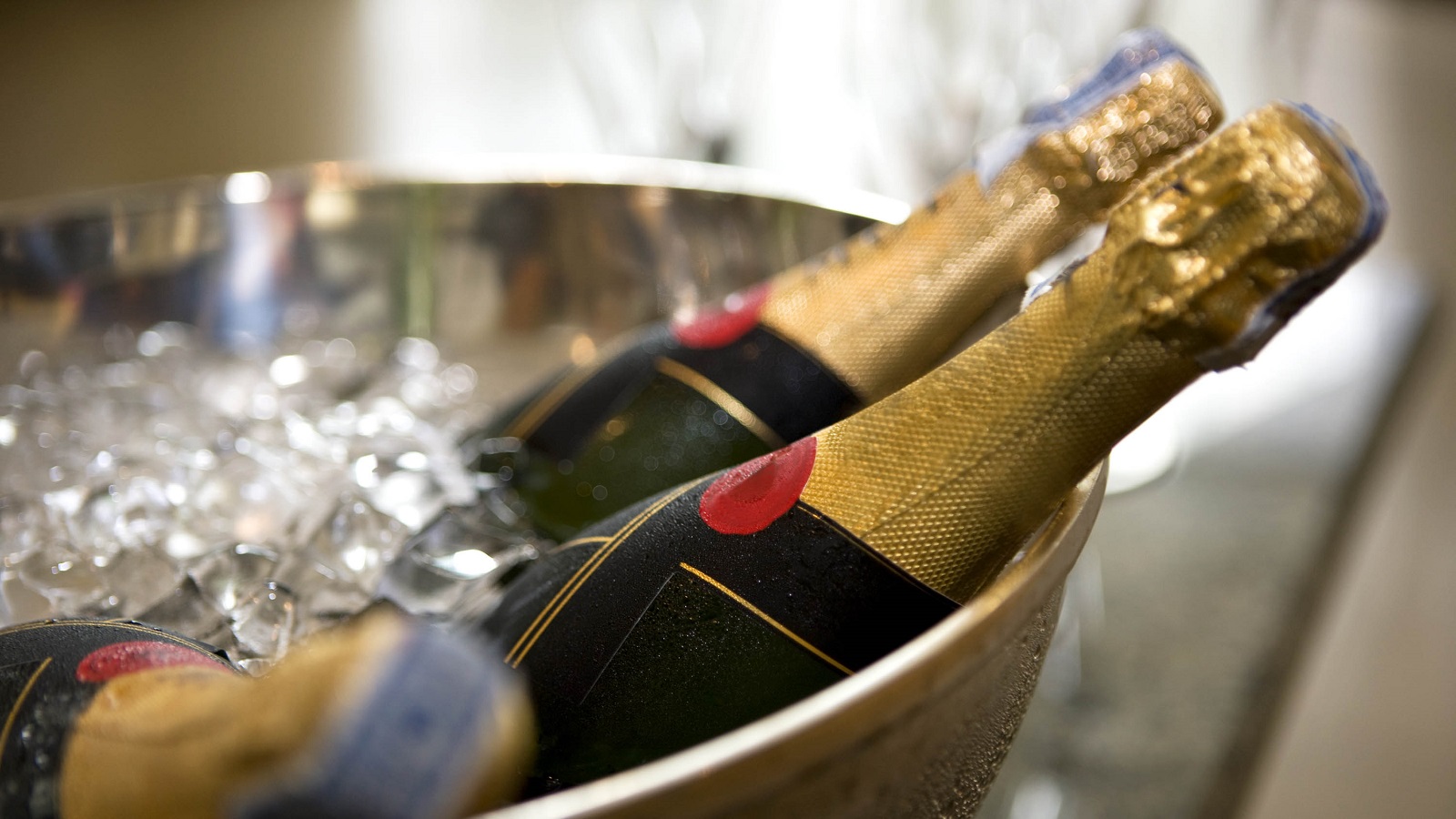 A pair of champagne bottles chilling on ice.