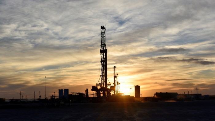 Drilling rigs operate at sunset in Midland, Texas