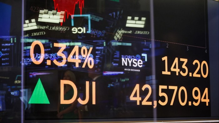 A monitor displays stock market information on the floor of the New York Stock Exchange