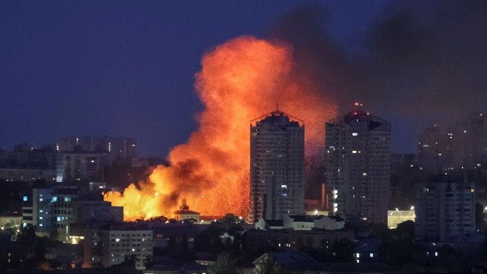A ball of fire rises behind a tower block in Kyiv, Ukraine