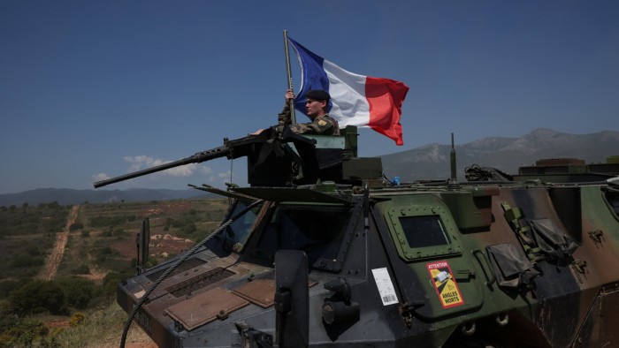 A member of the French army holds his national flag