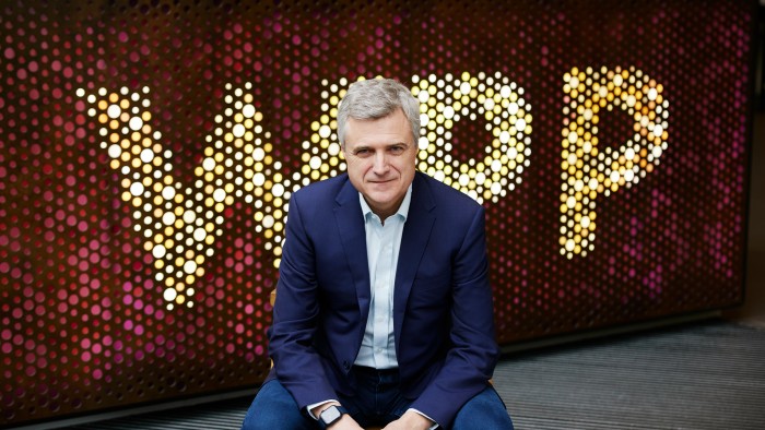 Mark Read sitting, with the WPP logo behind him