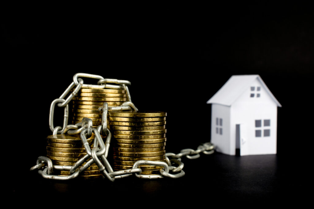 money chained gold coins white small house on a black background selective focus