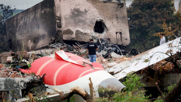 A firefighter stands next to the crashed Air India Boeing 787-8 Dreamliner aircraft, in Ahmedabad, India