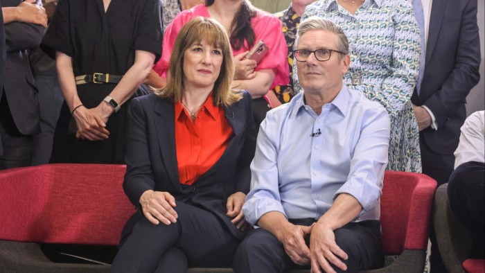 Rachel Reeves sits next to Keir Starmer on a red sofa