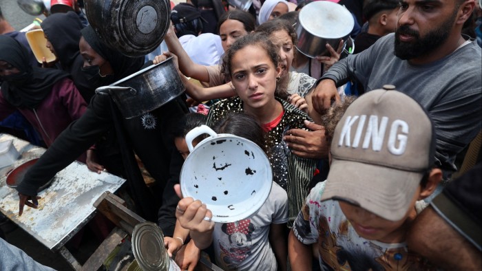 Palestinian children gather at a meal distribution point in central Gaza