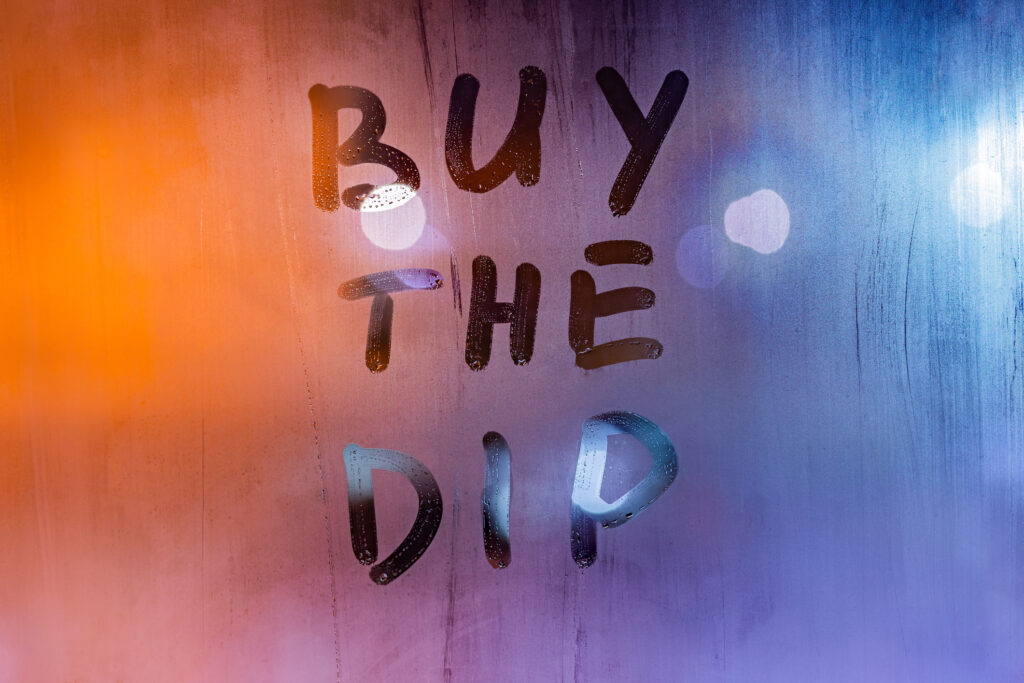 The investing strategy "buy the dip" written on a steamy window.