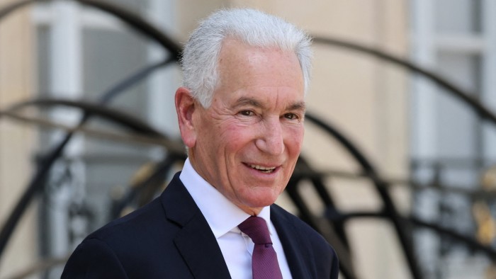 Charles Kushner smiles while wearing a dark suit and tie outside the Elysee Presidential Palace in Paris.