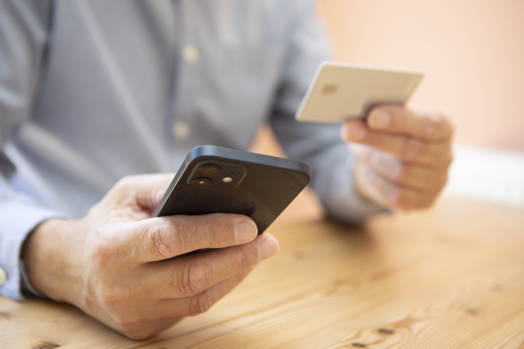 Close up of man holding a cell phone and credit card