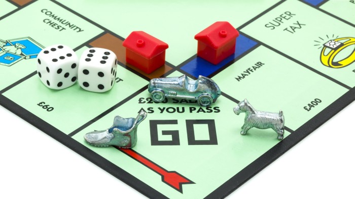 Monopoly board showing the ‘GO’ space with dice, red houses, and car, shoe, and dog player tokens.