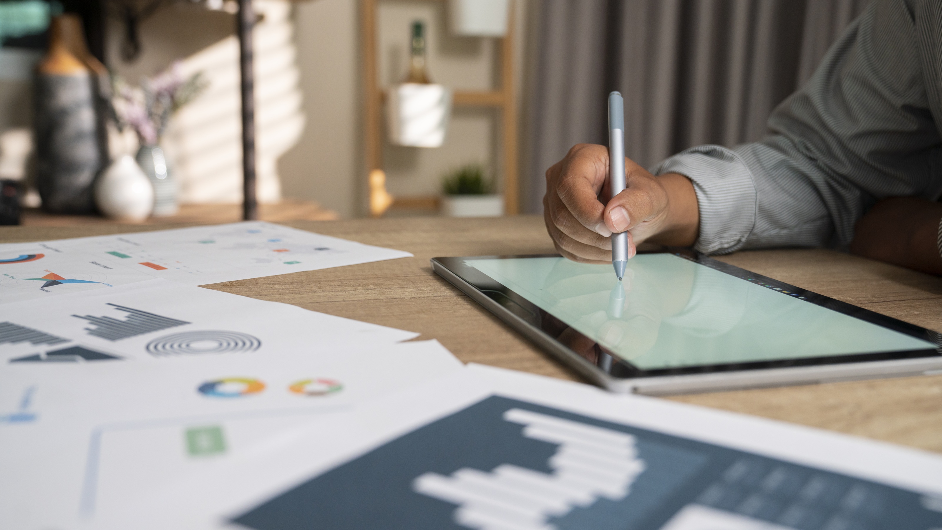 A man, only his hand showing, manages his portfolio at his desk.