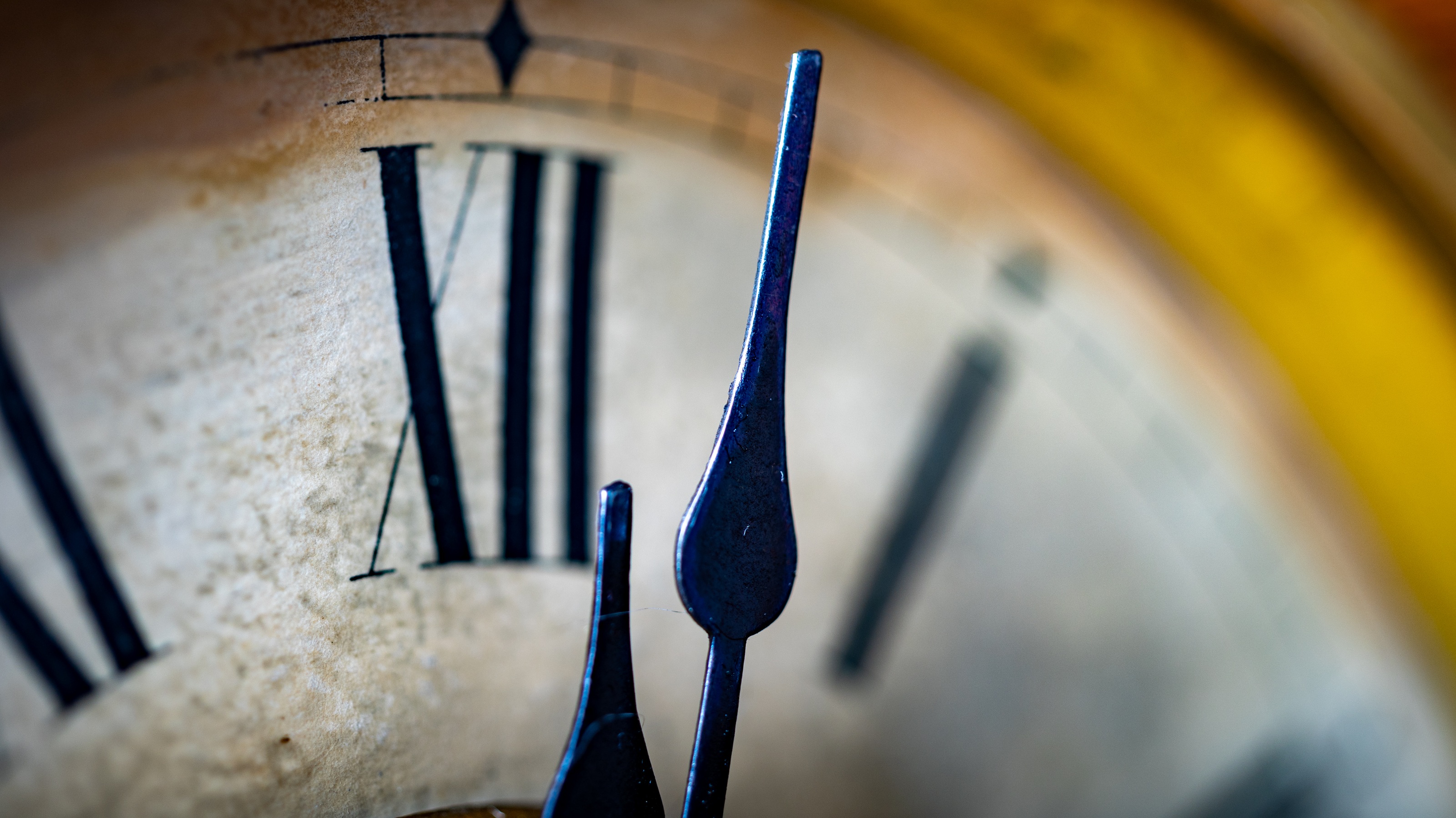 A clock with Roman numbers shows it's a few minutes past noon or midnight.