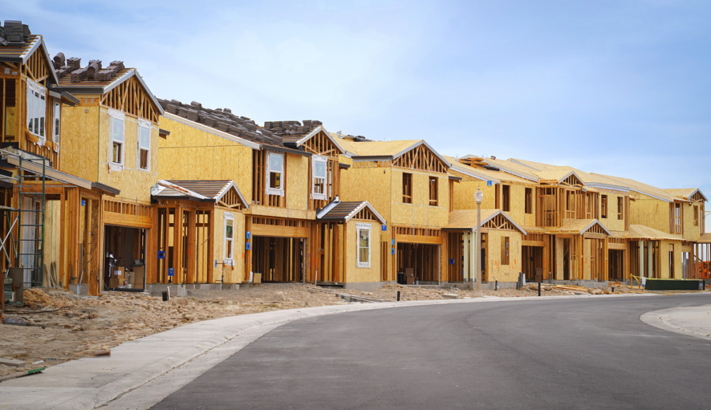 A row of houses sit under construction.