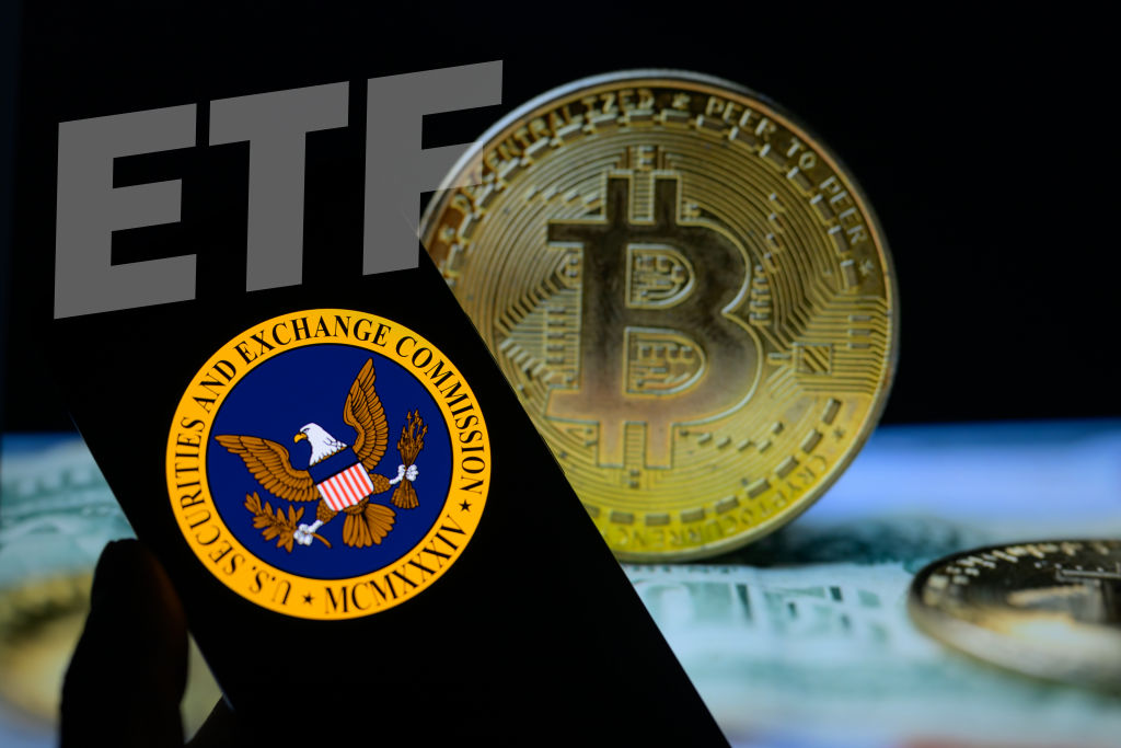 Seal of the U.S. Securities and Exchange Commission on a smartphone with Bitcoin visible on the screen in the background
