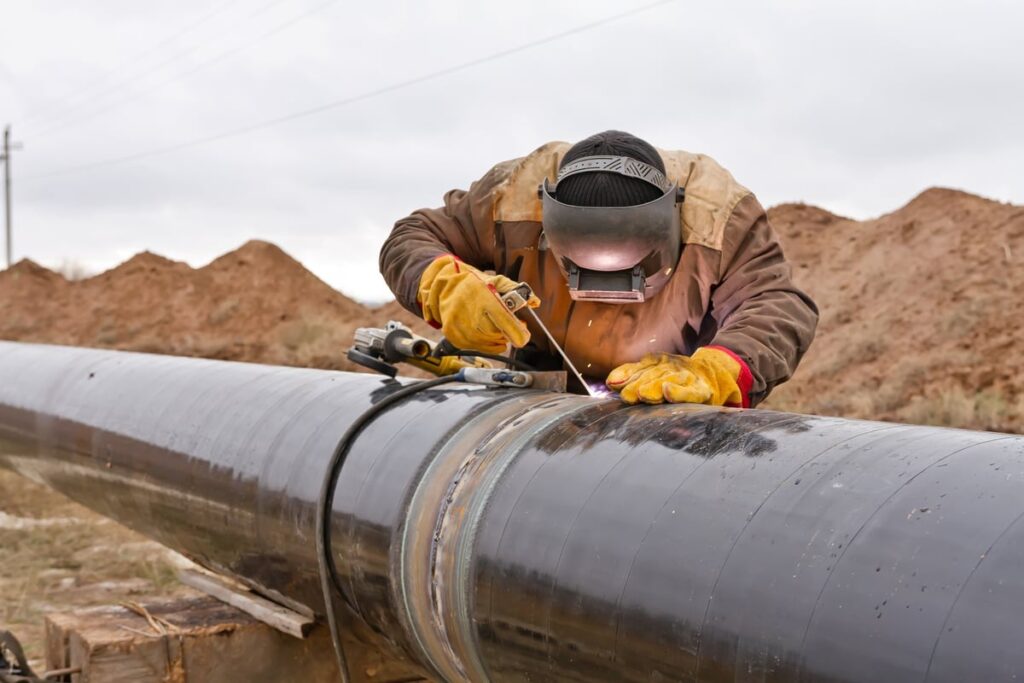 A worker welding a pipeline.