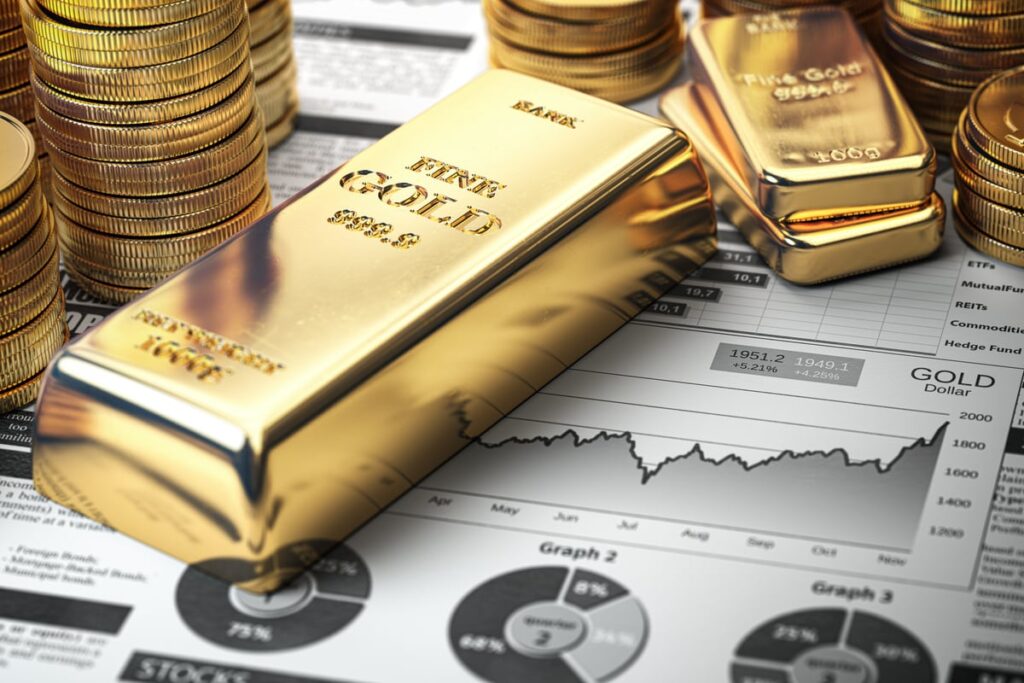 Gold bars, ingots, and coins set atop a newspaper detailing a financial forecast for precious metals.