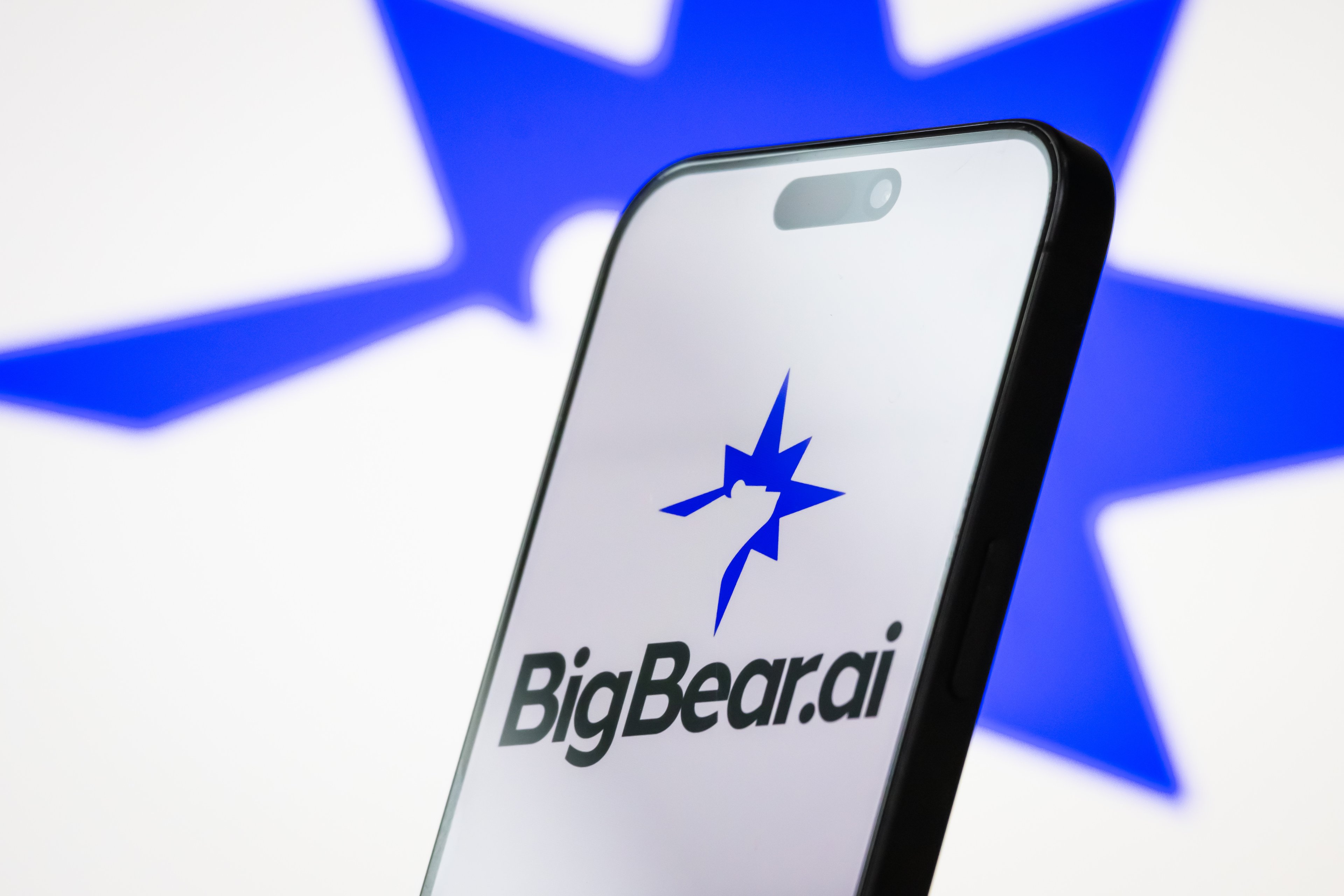 A smartphone displaying BigBear.ai's name and logo.