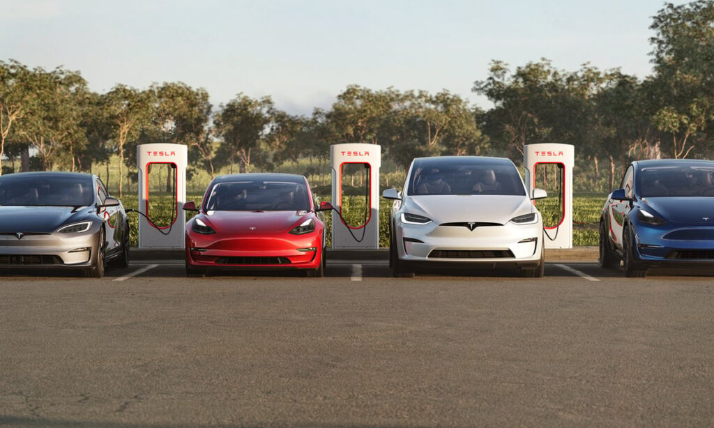 4 Tesla EVs in a parking lot at a charger station.