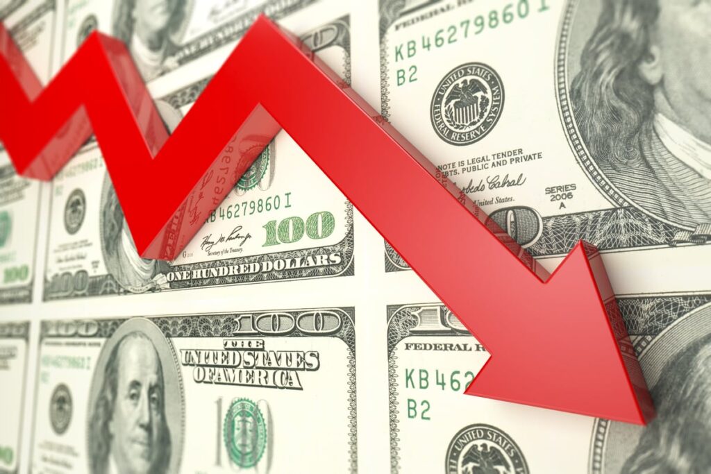 A downward-sloping red arrow in front of a sheet of hundred-dollar bills.