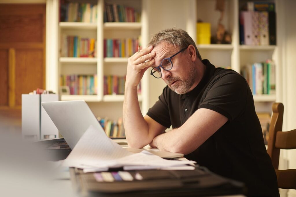 A person sits at a desk in front of a laptop computer.