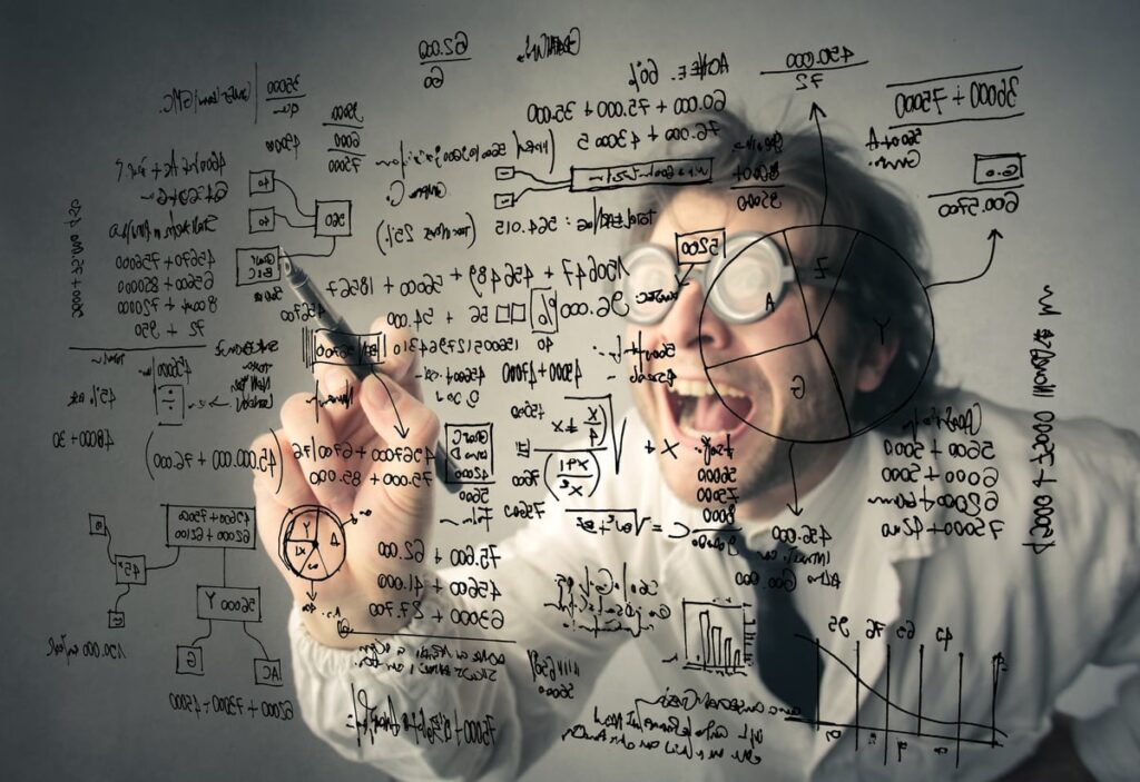 A mad-scientist type in a white jacket is making wild calculations on a clear blackboard.
