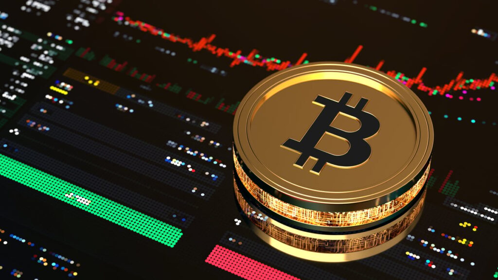 A golden Bitcoin rests on a screen displaying stock price data.