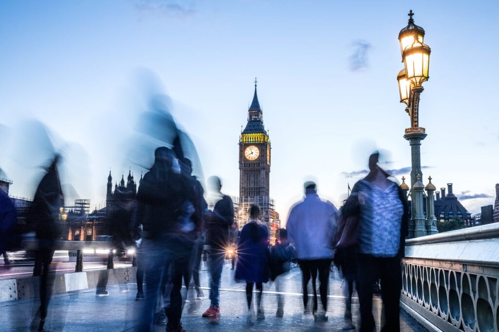People walking on London's Westminster Bridge, with Big Ben in background.
