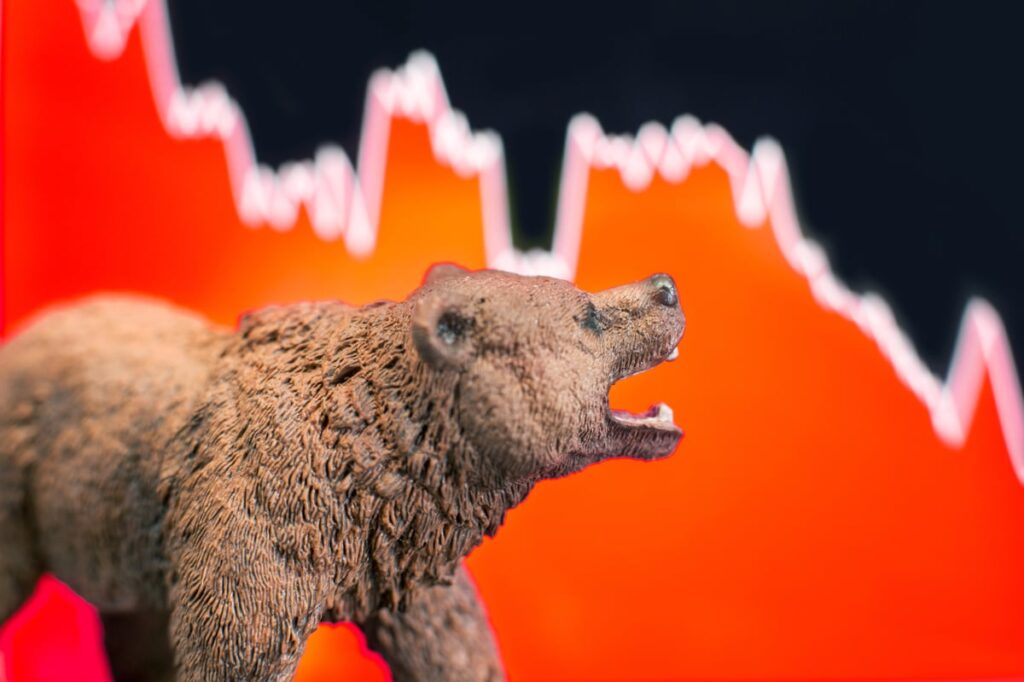 Bear figurine against a stock market downturn chart.