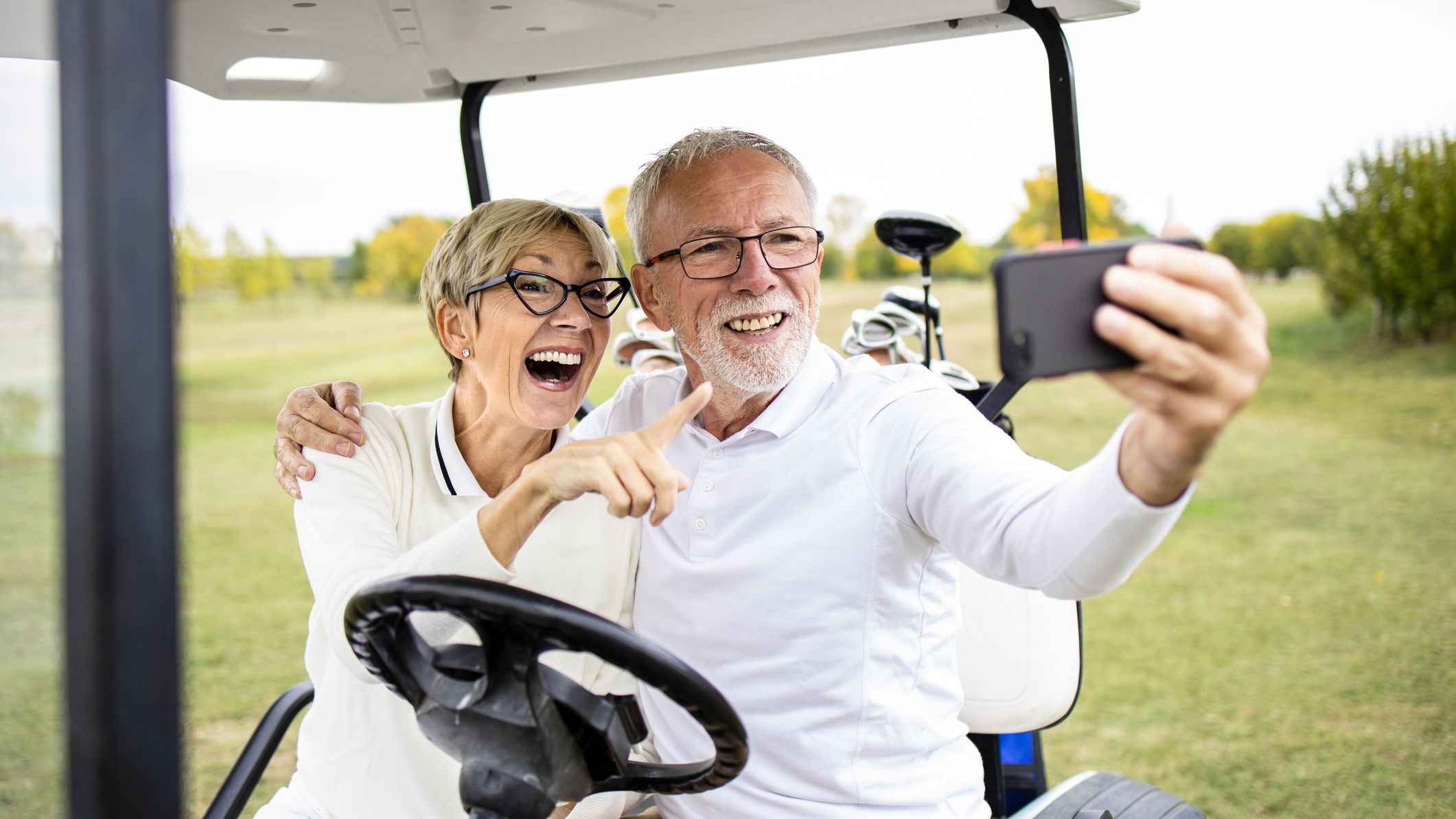 a couple taking a selfie on a golf cart