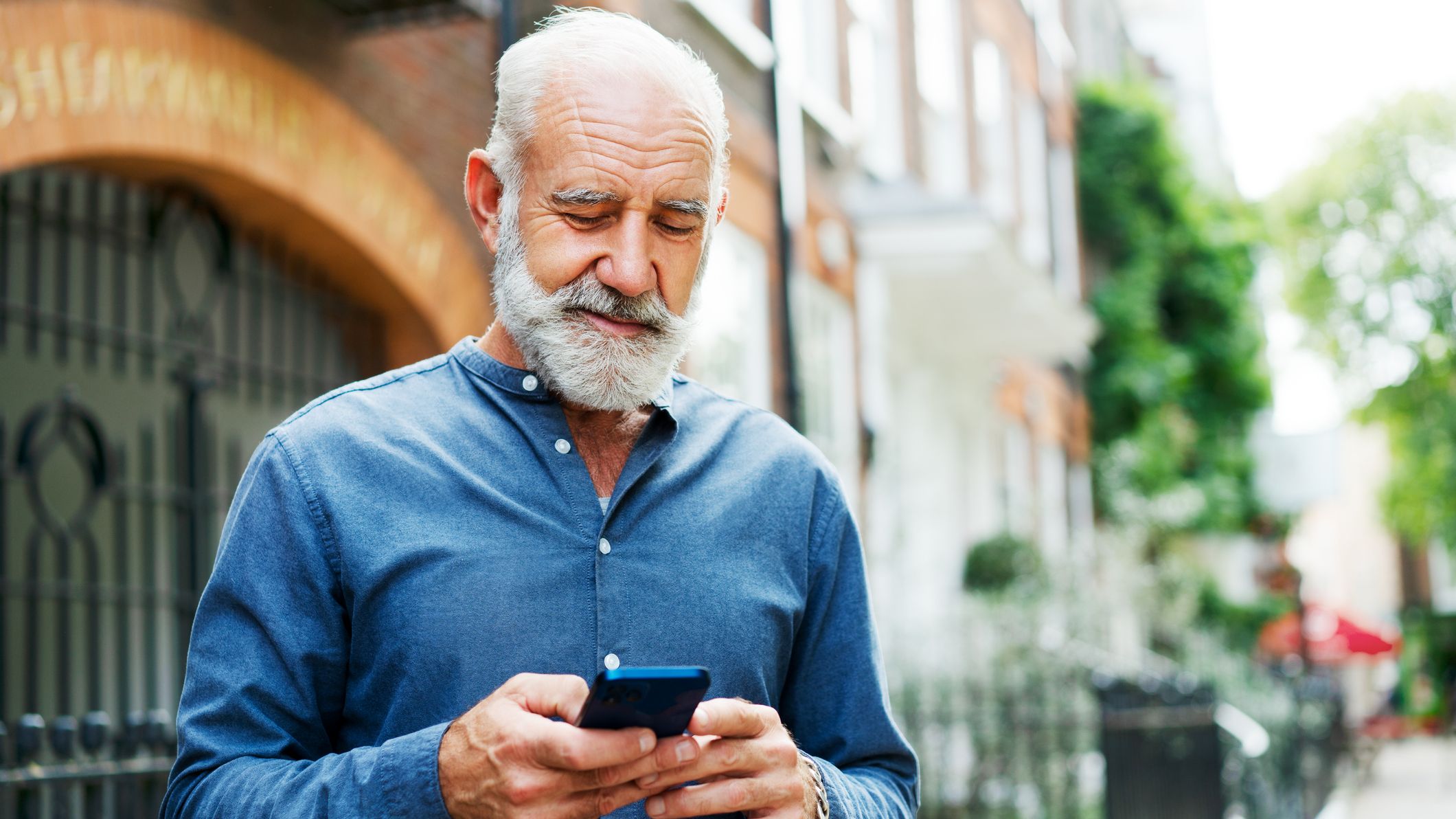 Man using smart phone, smiling