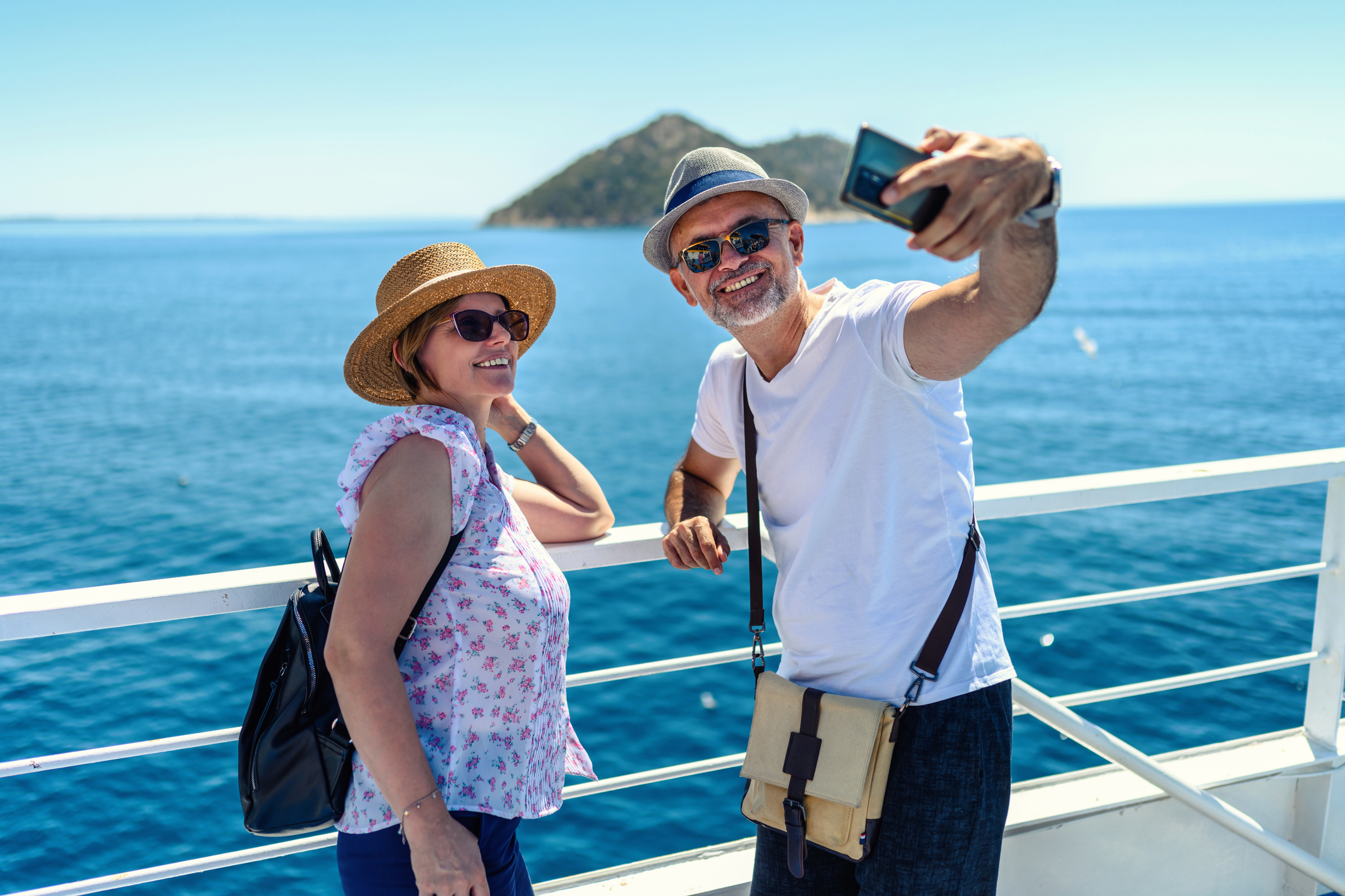 Mature couple on the boat deck on a sunny day traveling on vacation